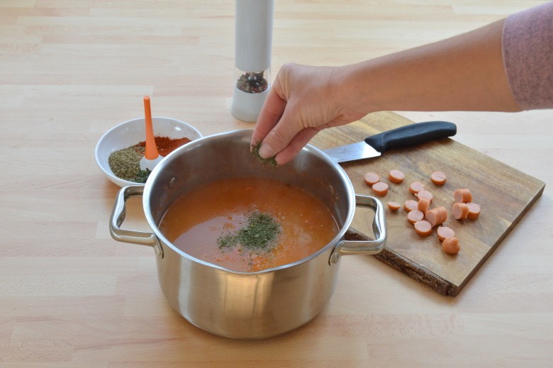 Dochucování frankfurtské polévky čerstvou nasekanou petrželkou